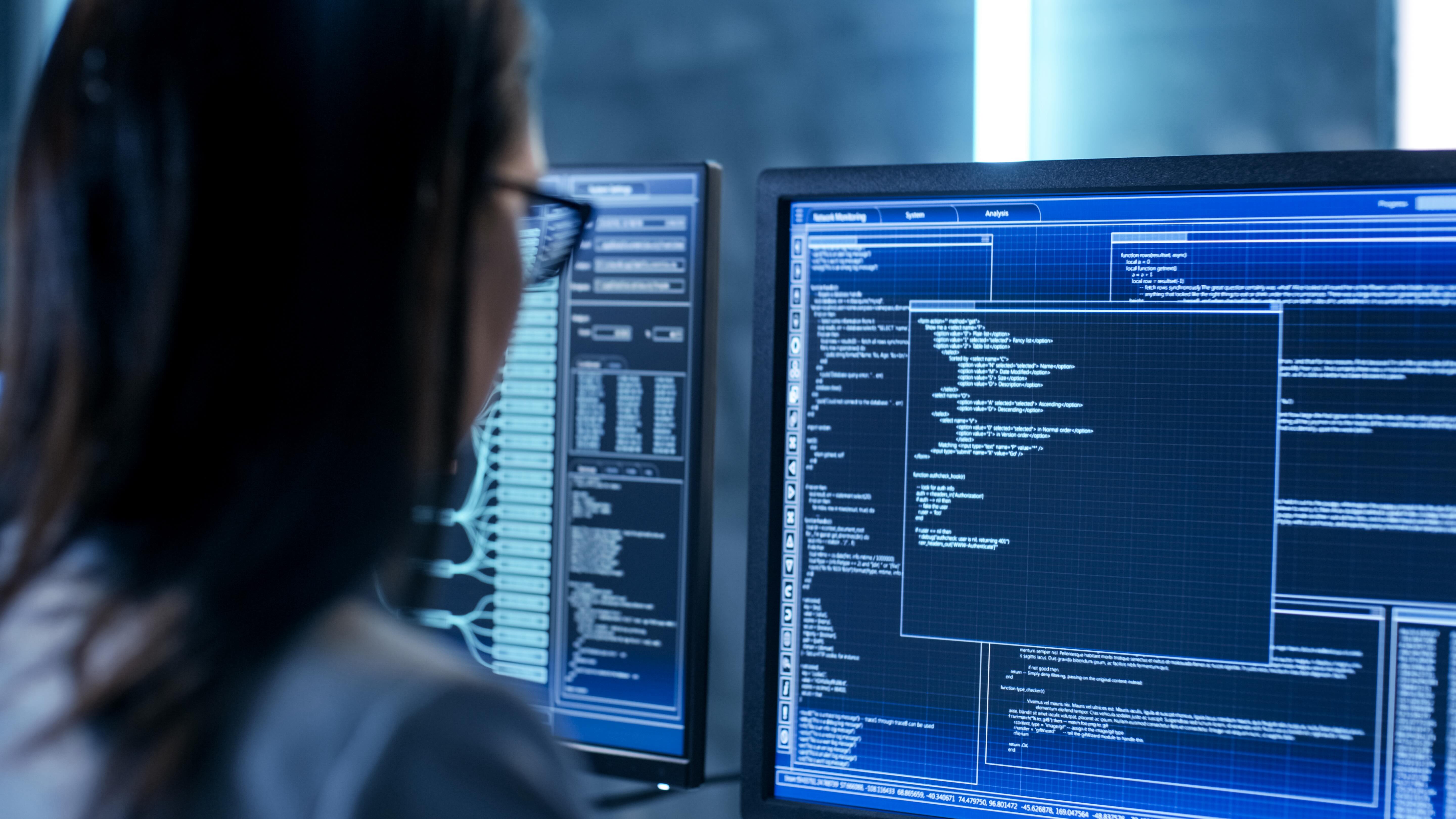 A woman looks at a computer screen in a work environment