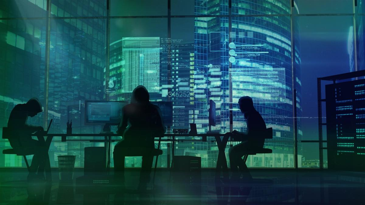 Image of three hackers coding in a darkened conference room with a view outside the window of several high rises